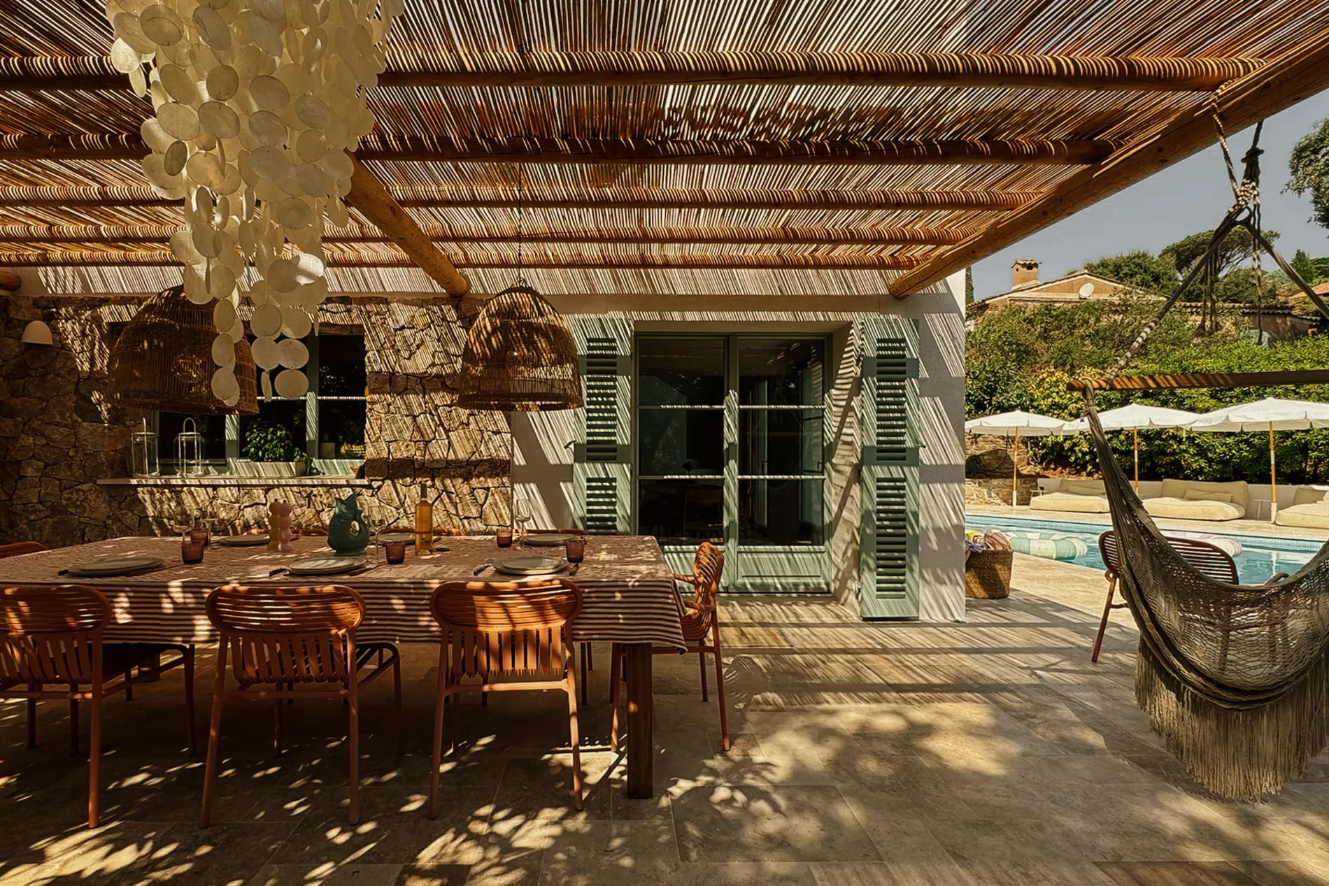 Pergola dining area beside the pool with a hammock